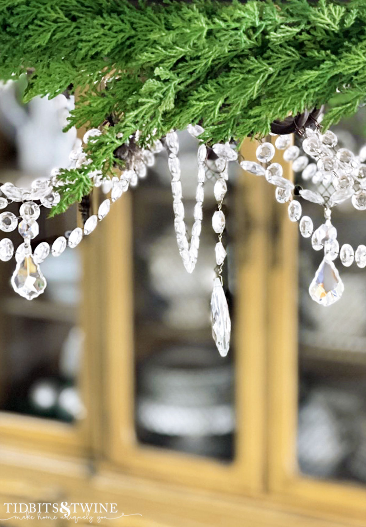 faux garland attached to french crystal chandelier as christmas decor