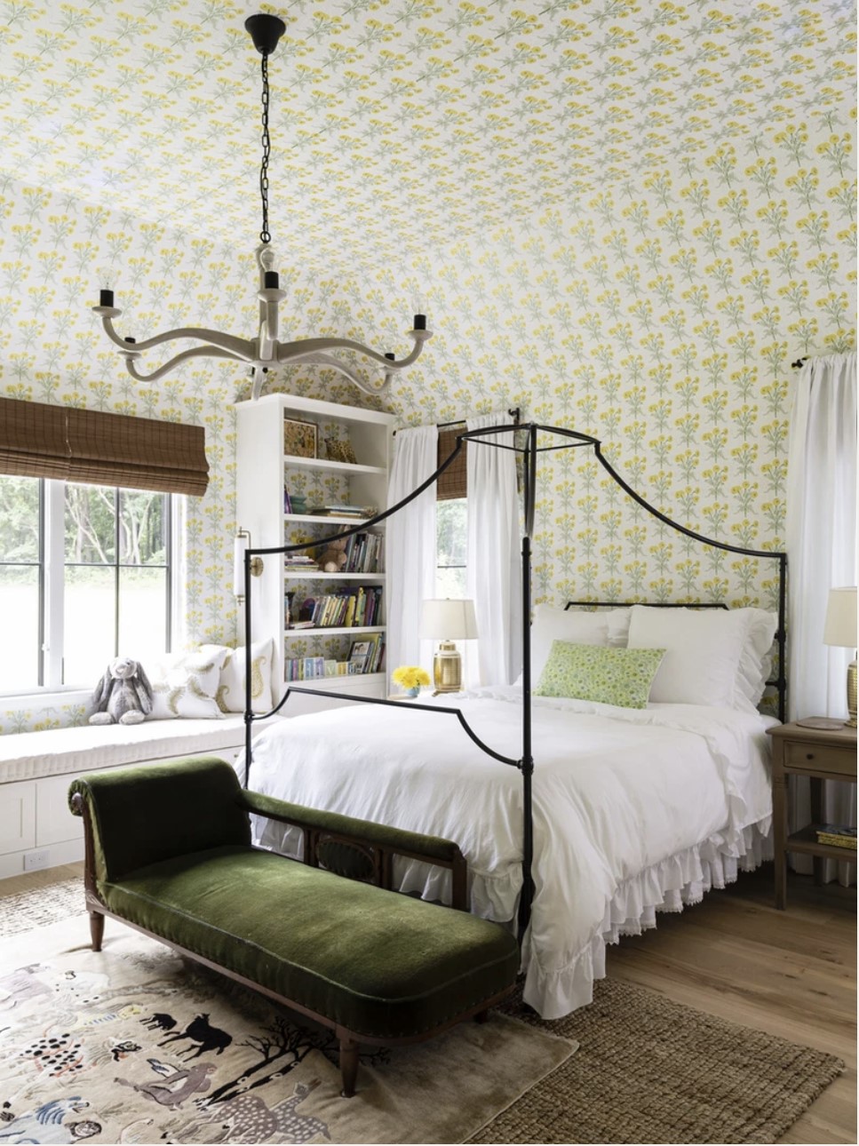 bedroom with yellow and white floral wallpaper and black french canopy bed and white bedding