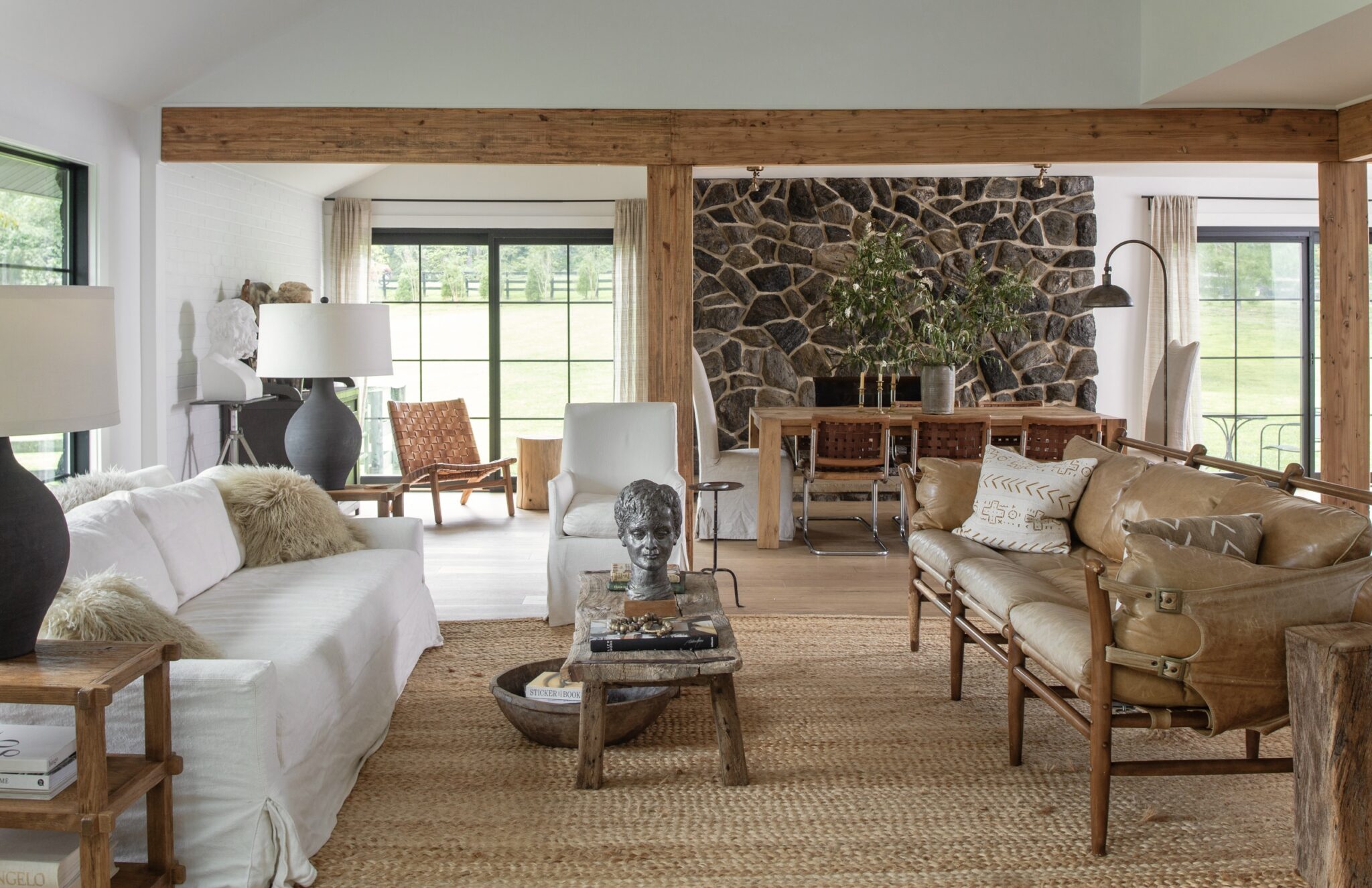 neutral living room with white sofa and leather couch and rustic wood coffee table and jute rug