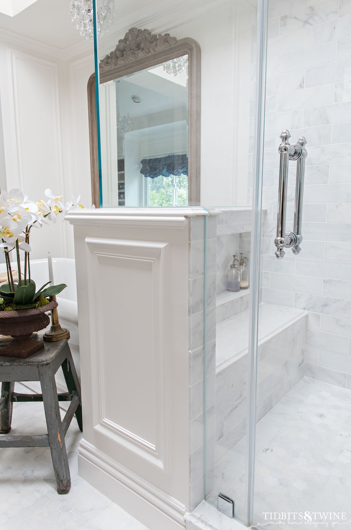 carrara marble shower with bench and niche with a pony wall with molding