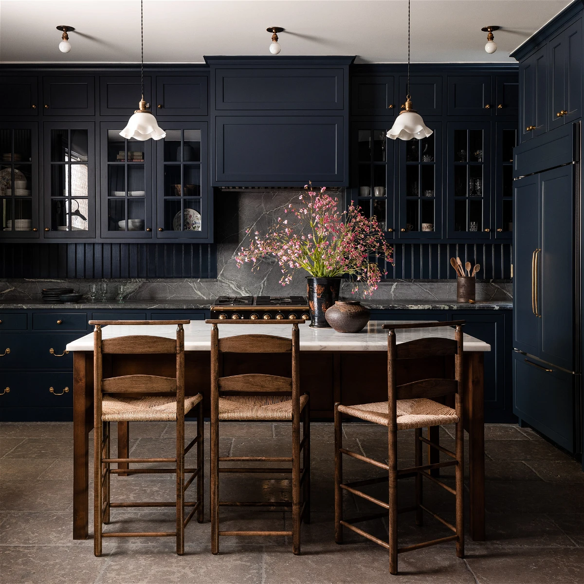 dark navy kitchen cabinets with wood floor and dark stained island
