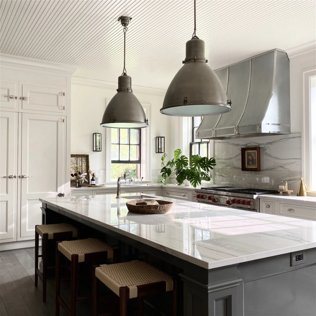 white and gray kitchen with metal hood and industrial sconces