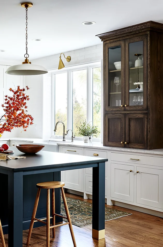 white lower kitchen cabinet with blue island and dark wood upper cabinet