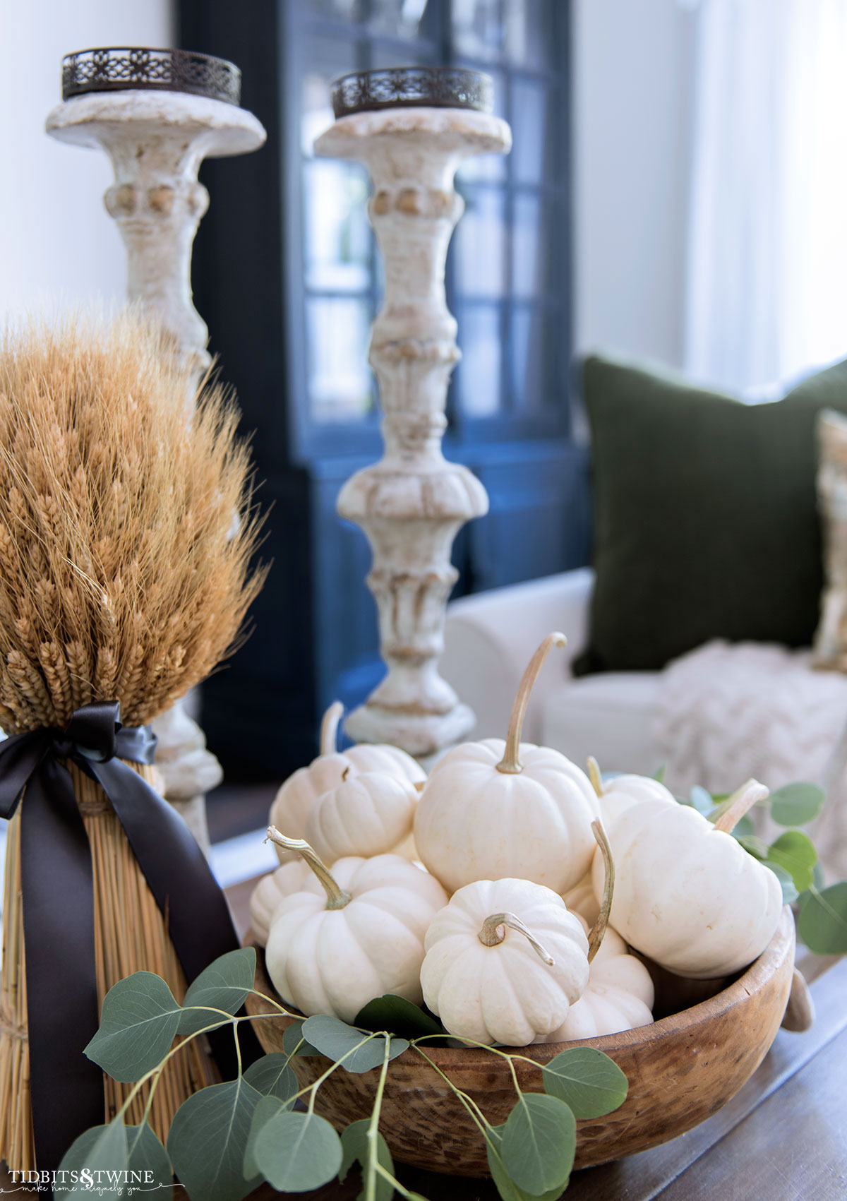 vignette of wooden dough bowl with white pumpkins and fresh eucalyptus with dried wheat bunch
