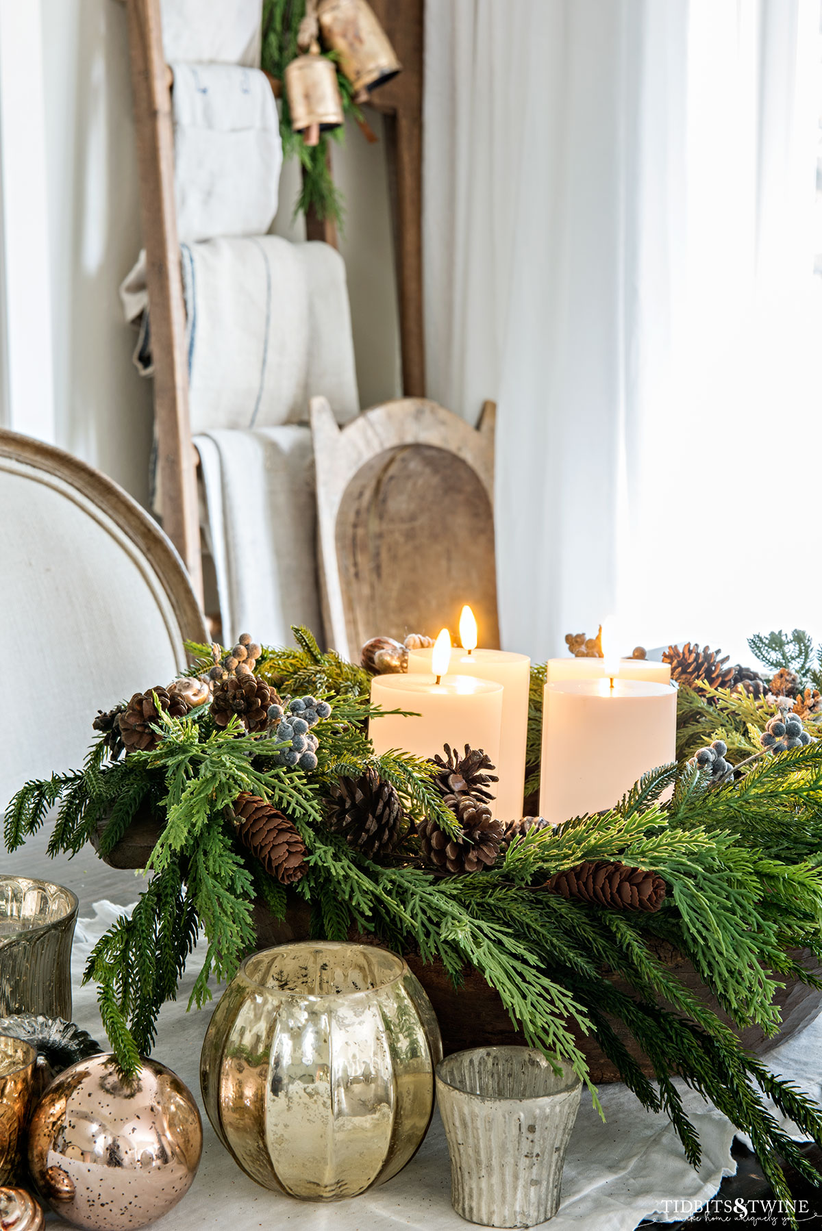 dining table with diy advent wreath in center with four white pillar candles and mercury glass votives on the table