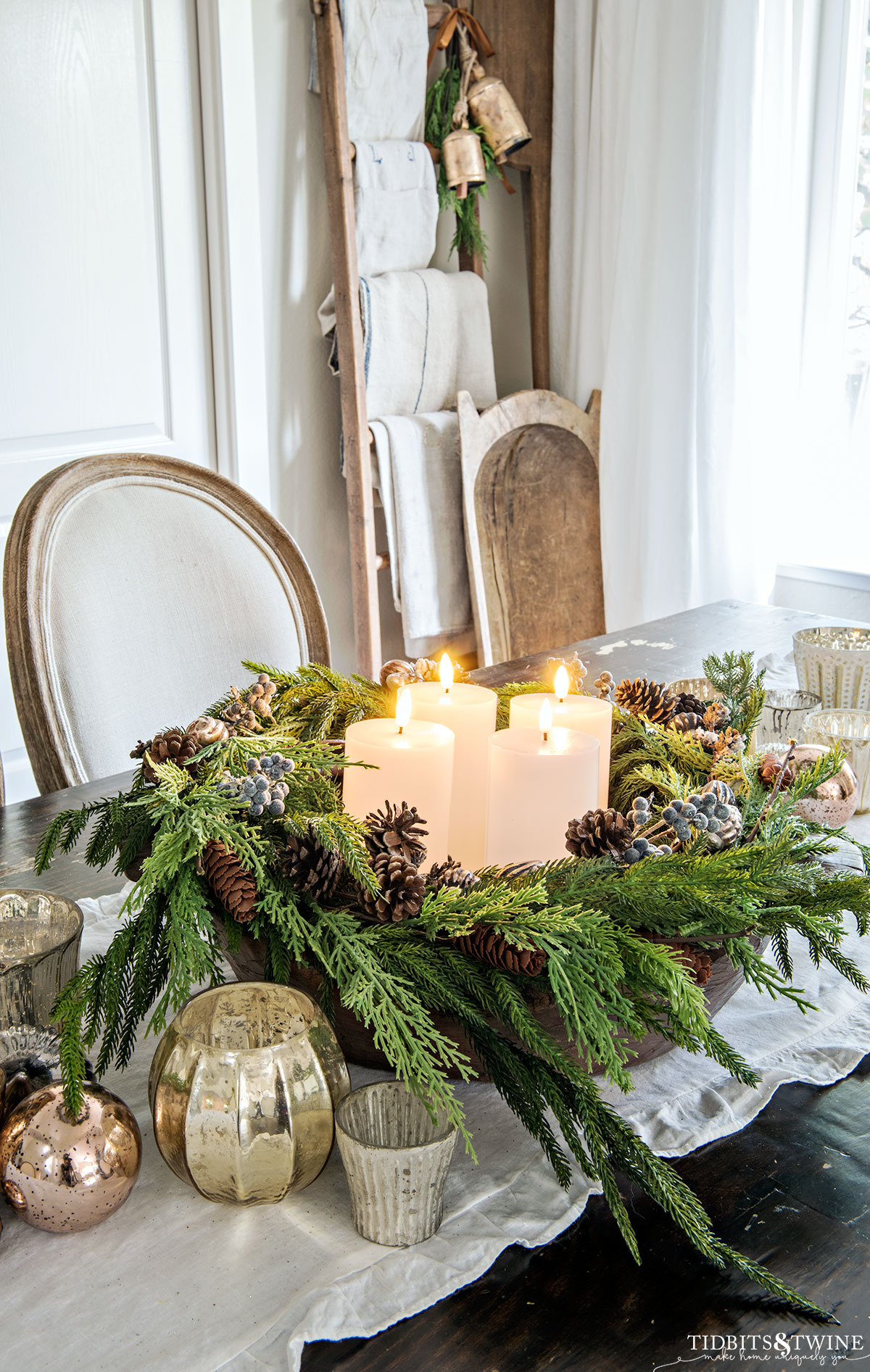 dining room with french linen chairs and advent wreath in center of table and ladder with grain sacks in corner