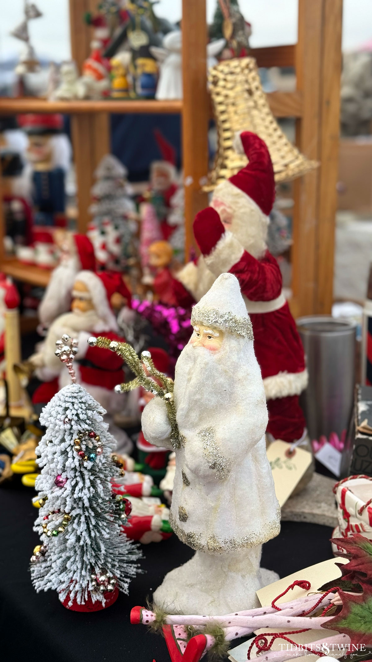 antique white Christmas santa and other Christmas decor on a table at an antique fair