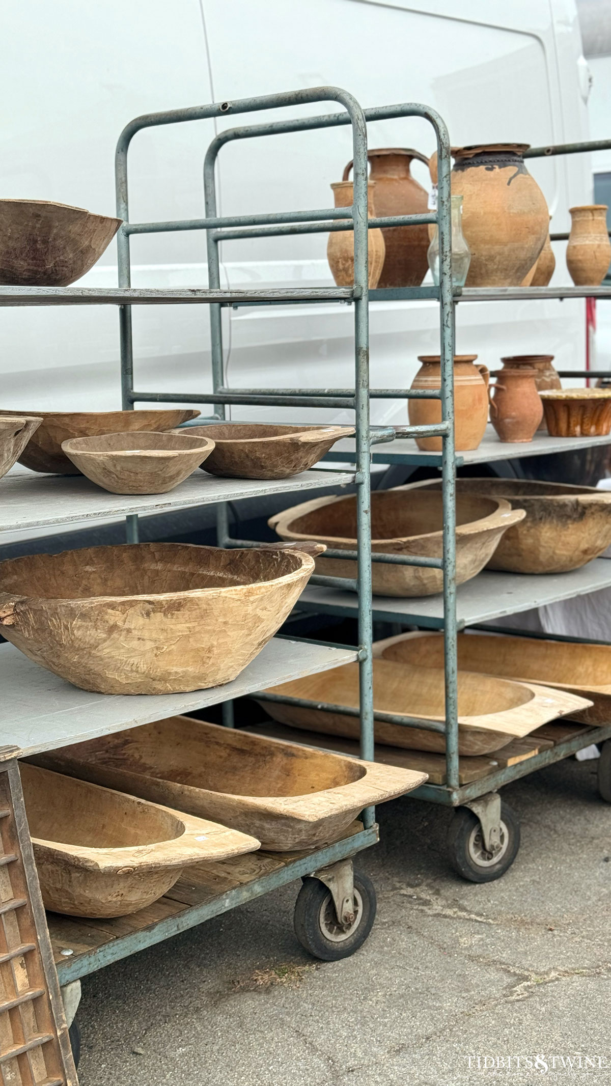 racks of antique dough bowls in all sizes on display at an antique fair