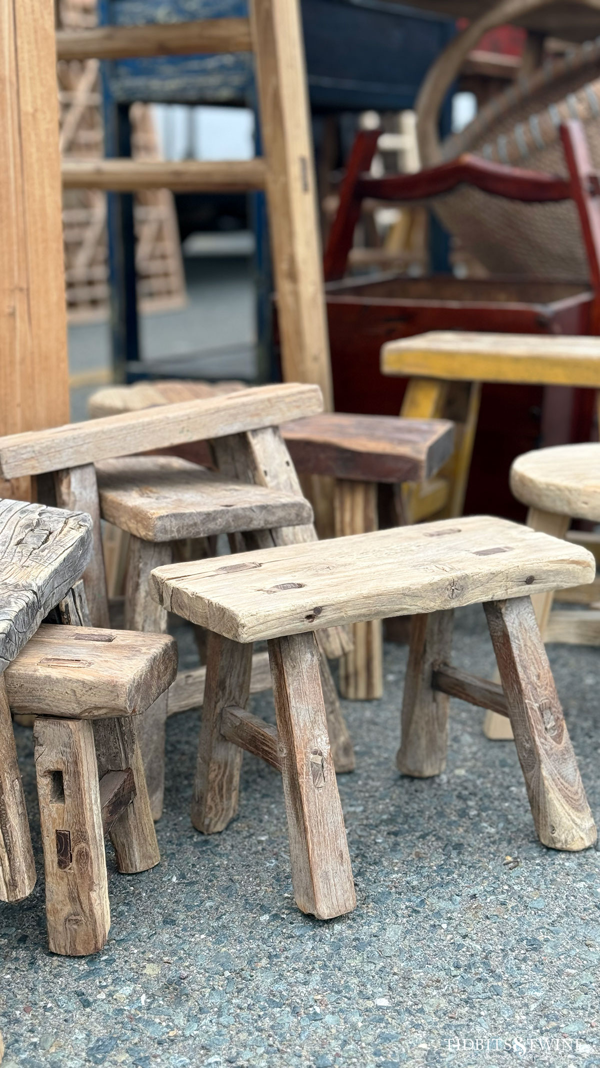 Small antique wooden stools risers displayed on the ground at an antique fair