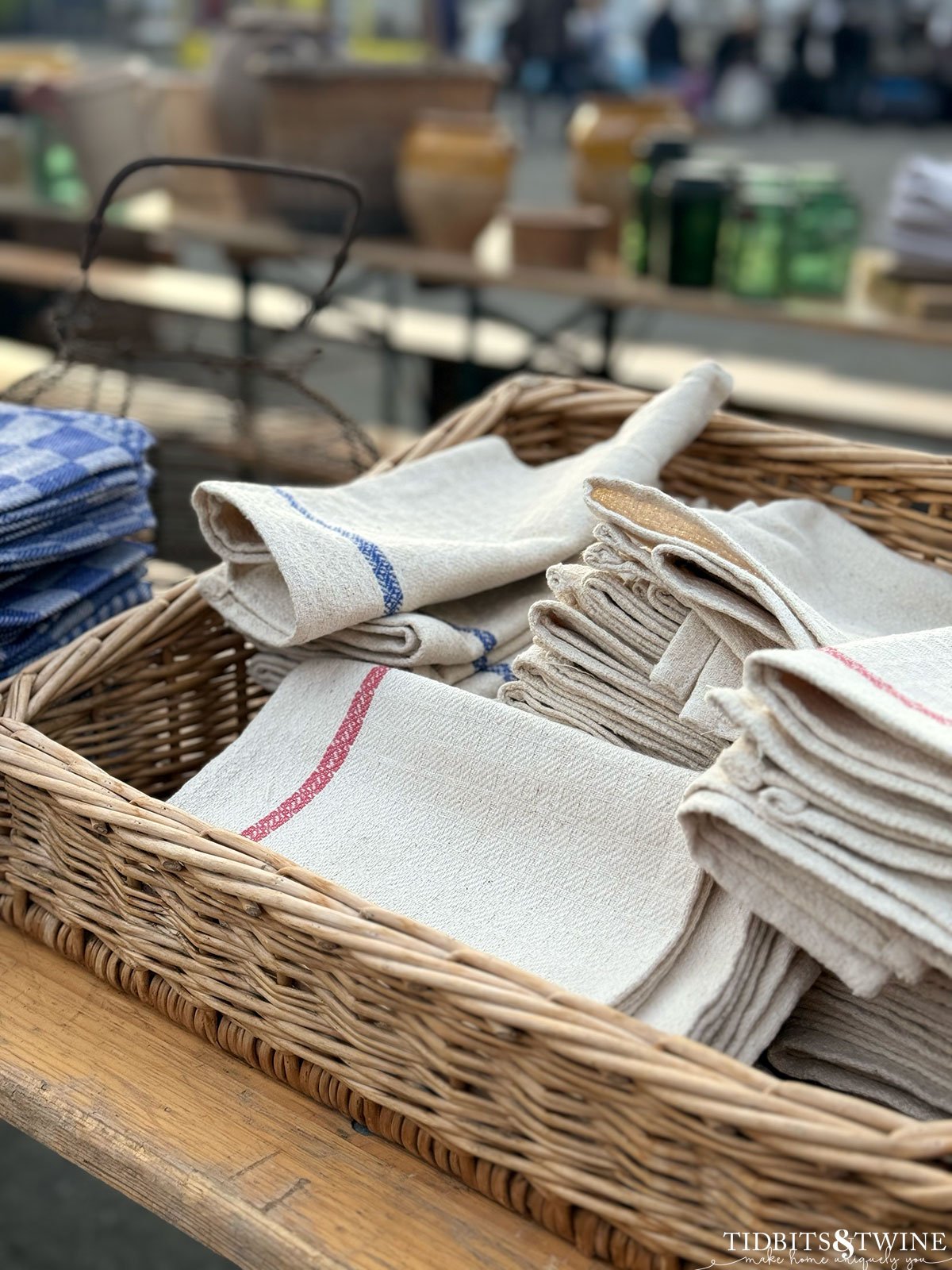 basket holding grain sack napkins on display on a table at an antique fair