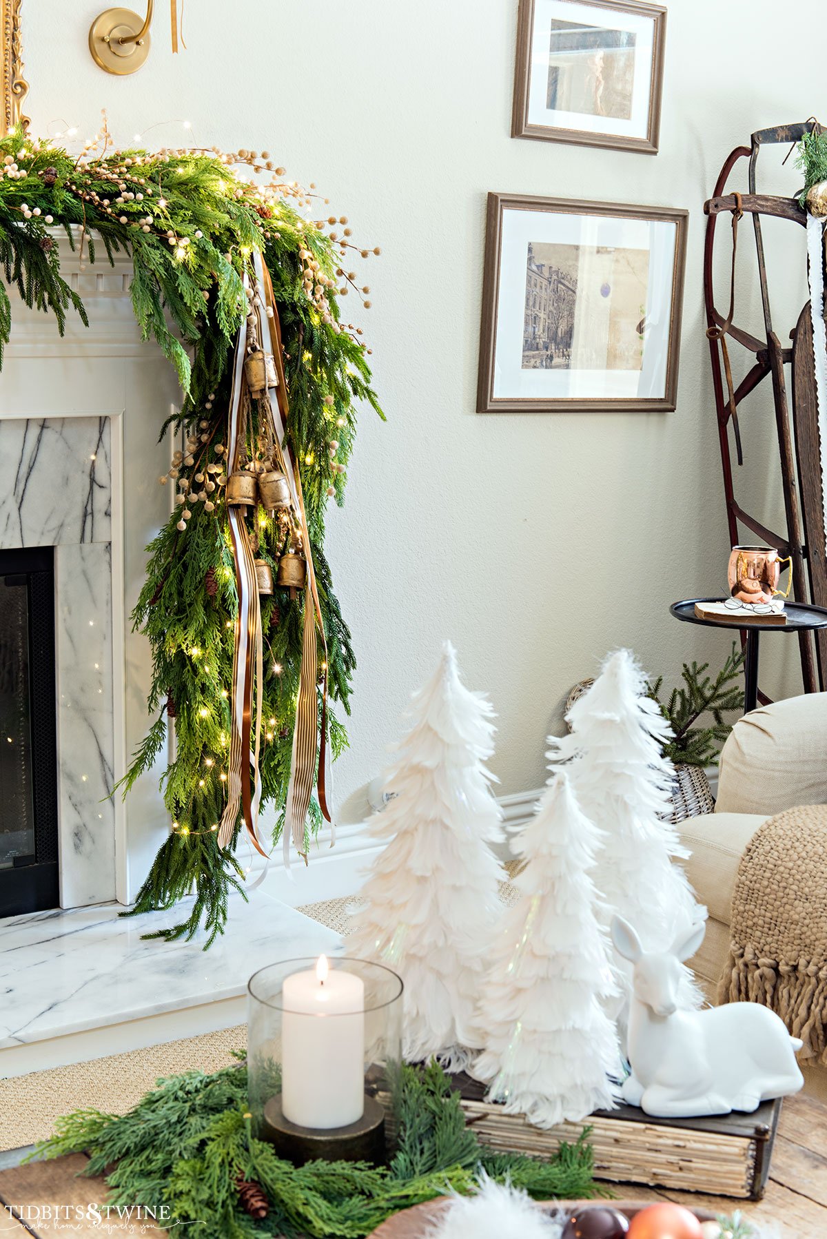 corner of french living room coffee table decorated for christmas with asymmetrical garland on fireplace mantel