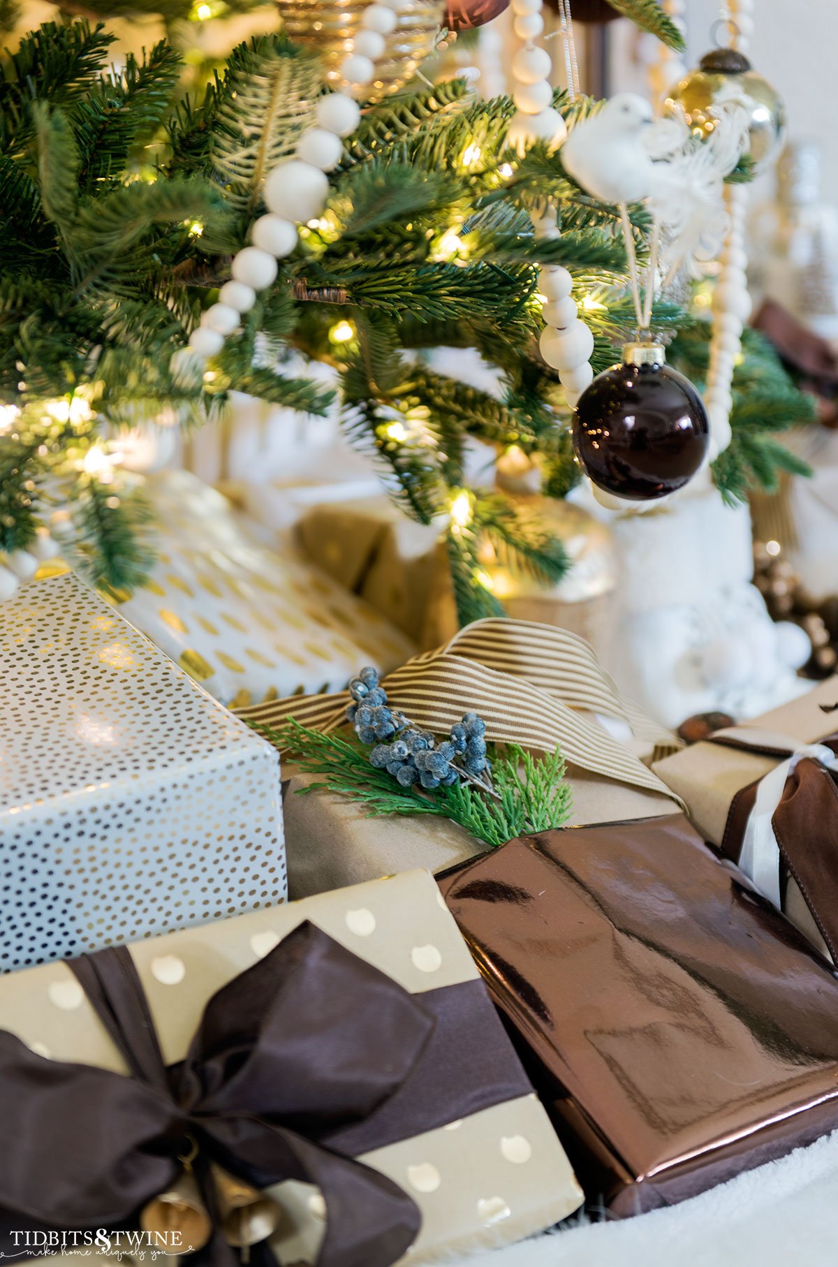closeup of wrapped presents under a christmas tree with rust and brown and gold paper