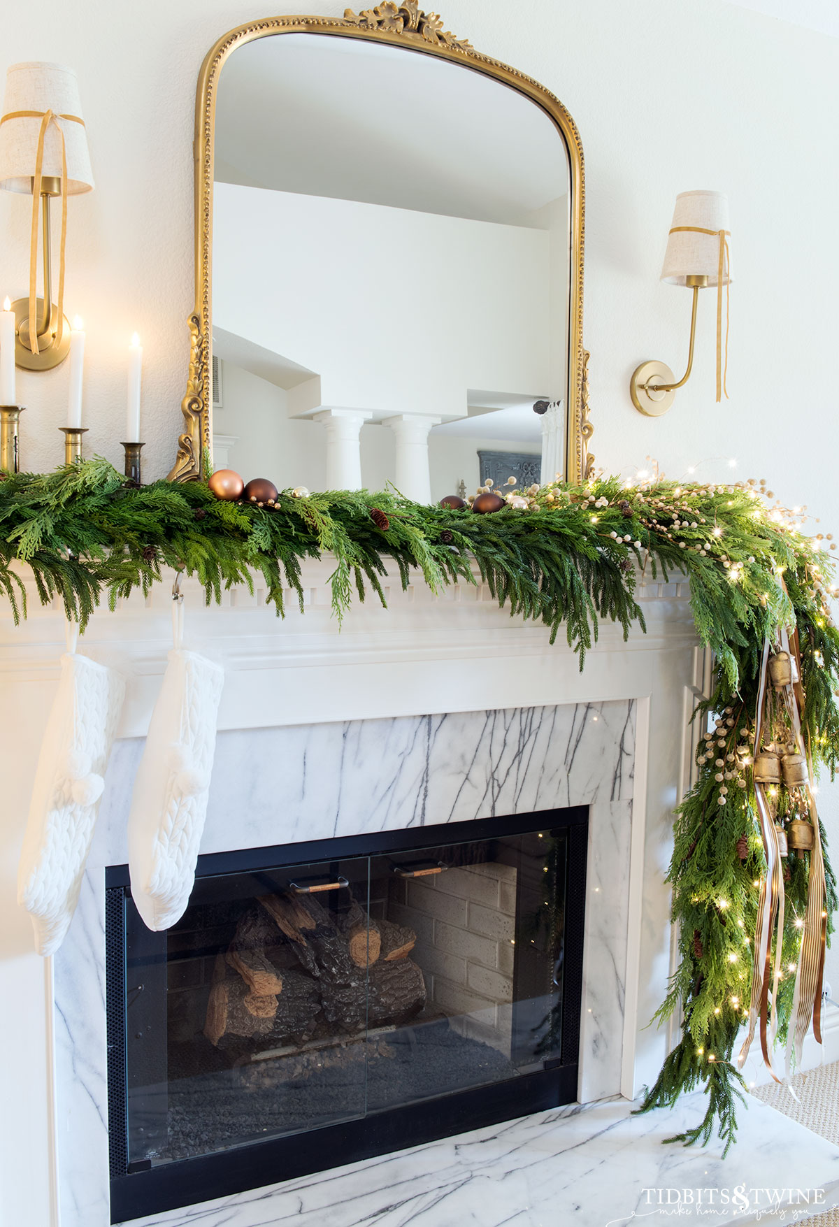 christmas garland on fireplace mantel with copper ornaments lights bells and ribbon
