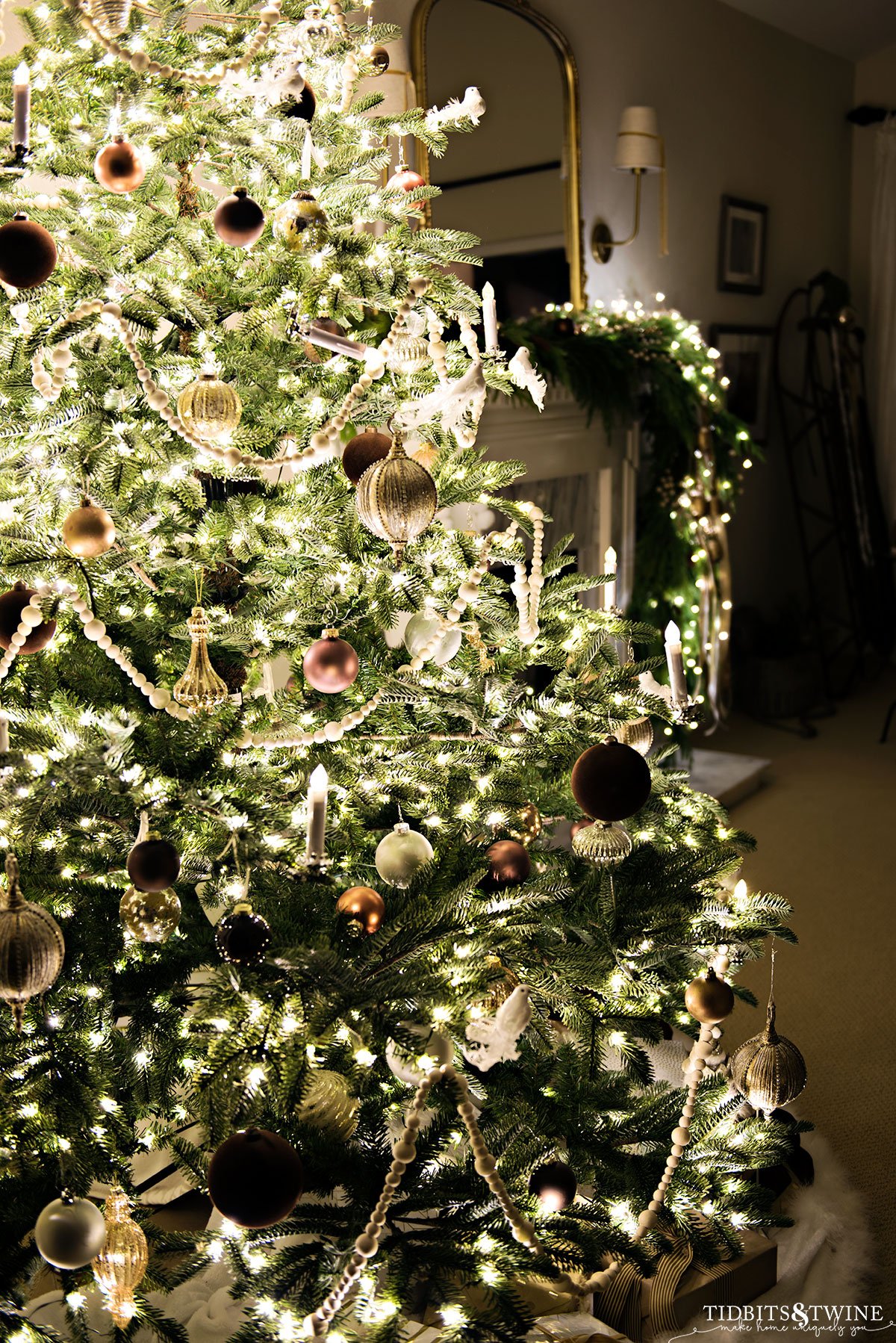 neutral french christmas tree at night with fireplace in background