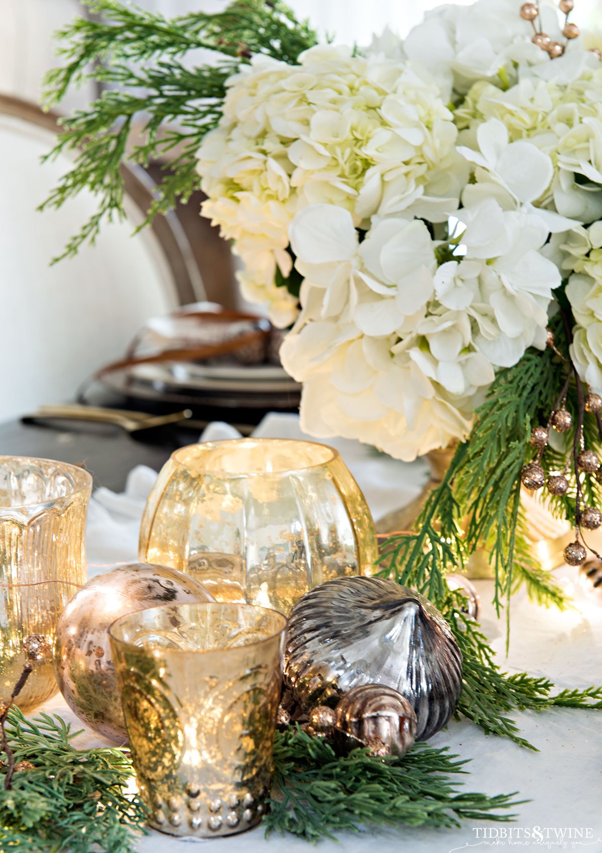 closeup of christmas votives on dining room table next to hydrangea centerpiece