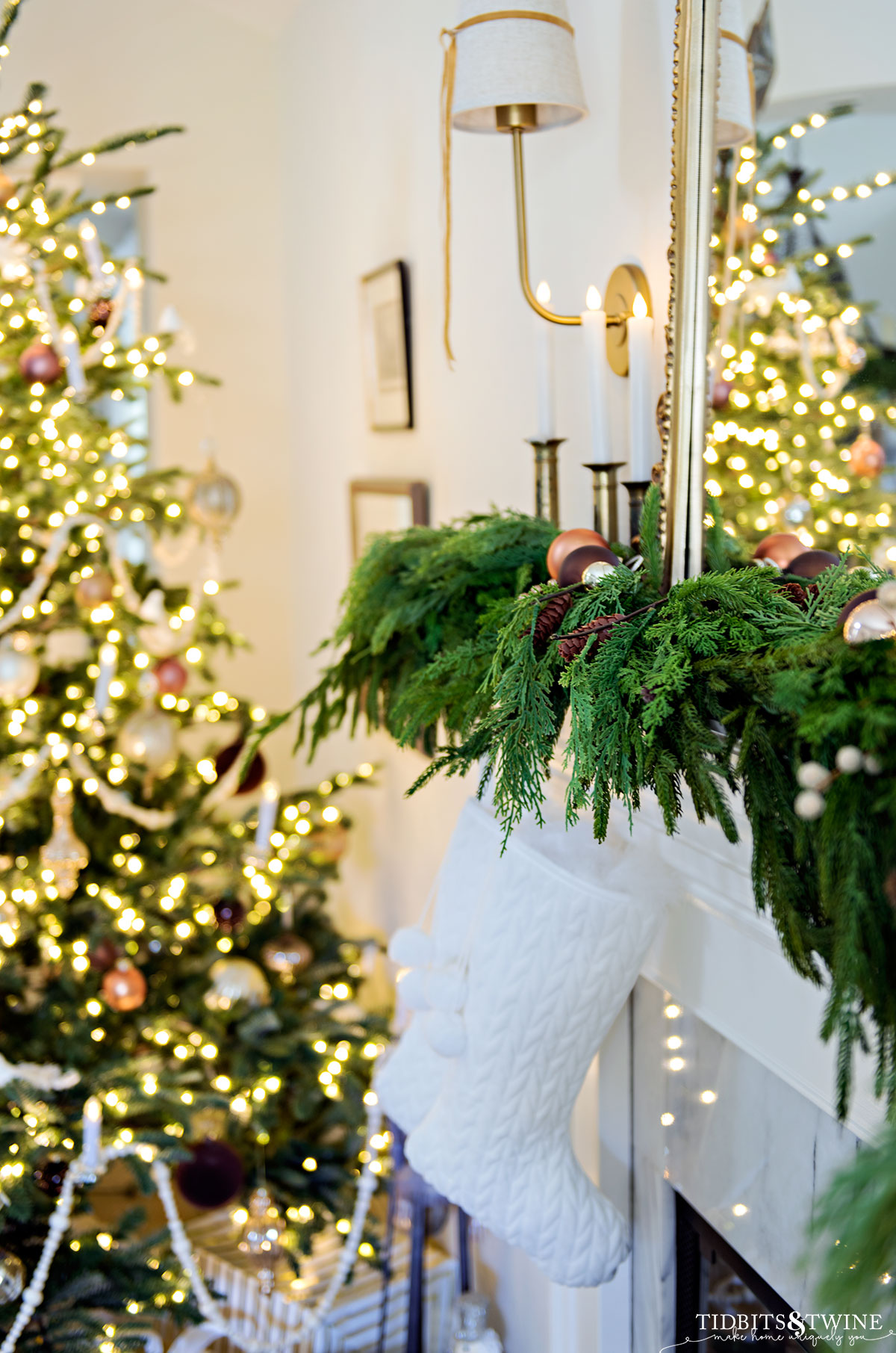 faux greenery christmas garland with white velvet stockings and reflection of tree in mirror