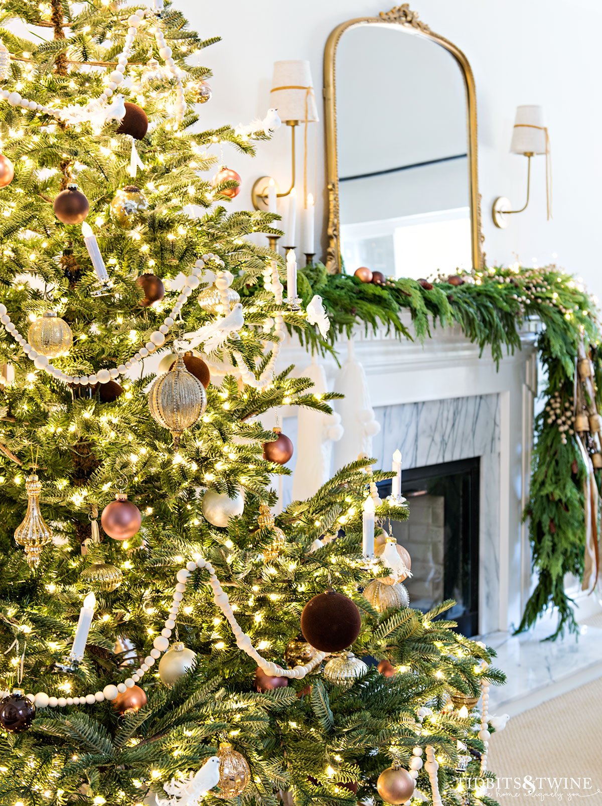 decorated french christmas tree with fireplace mantel and garland in the background