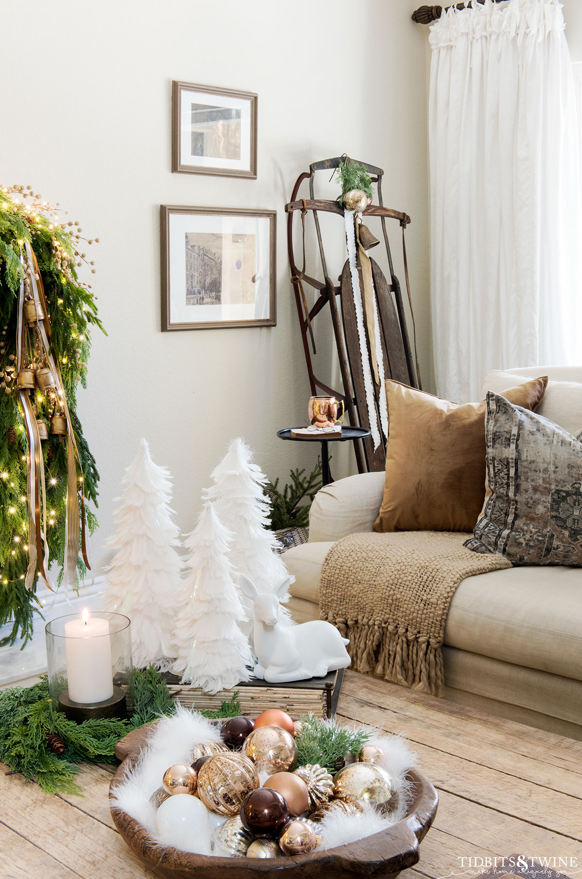 living room with antique sled propped up in corner and coffee table decorated for christmas in front