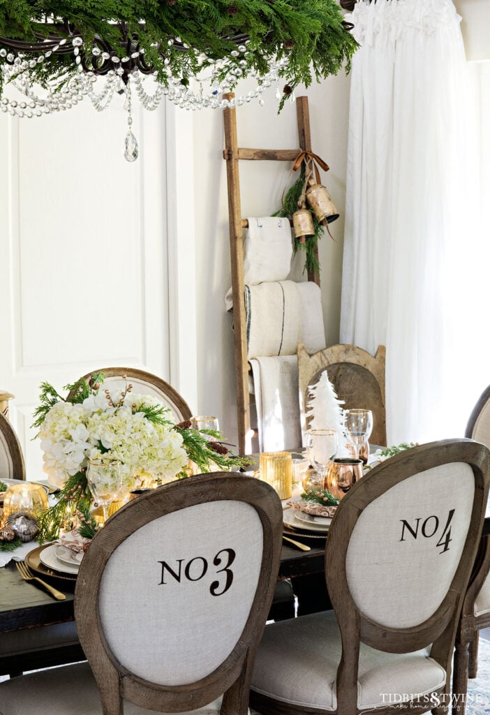 french christmas dining room decorated with neutrals and round linen numbered chairs