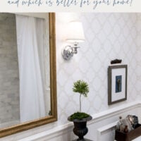 bathroom with trellis wallpaper and wall sconce next to wood mirror