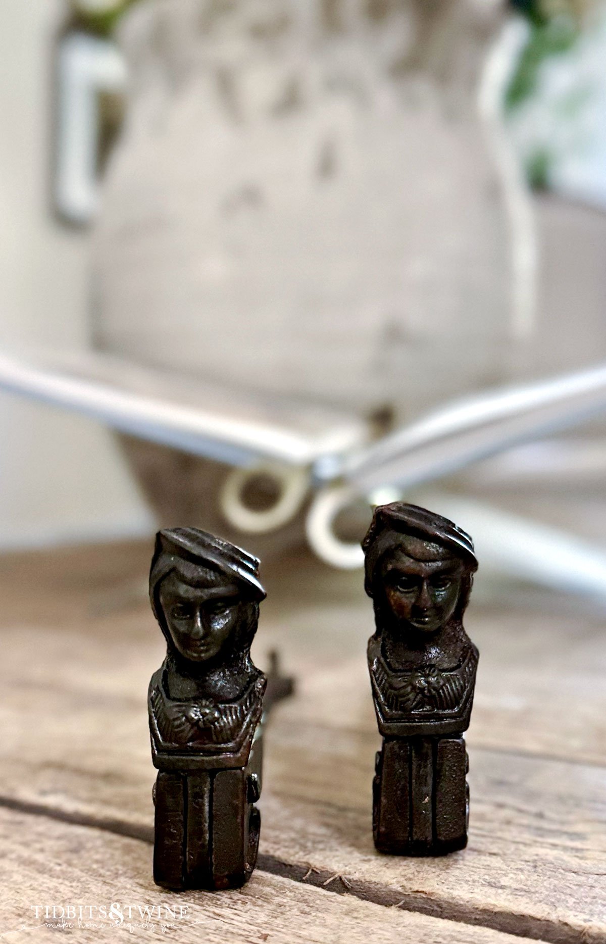 two iron french antique shutter dogs on a coffee table