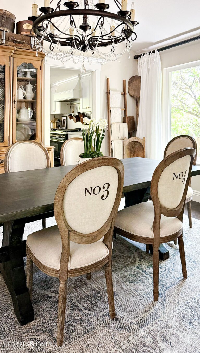 dining room with brown trestle table and french linen dining chairs
