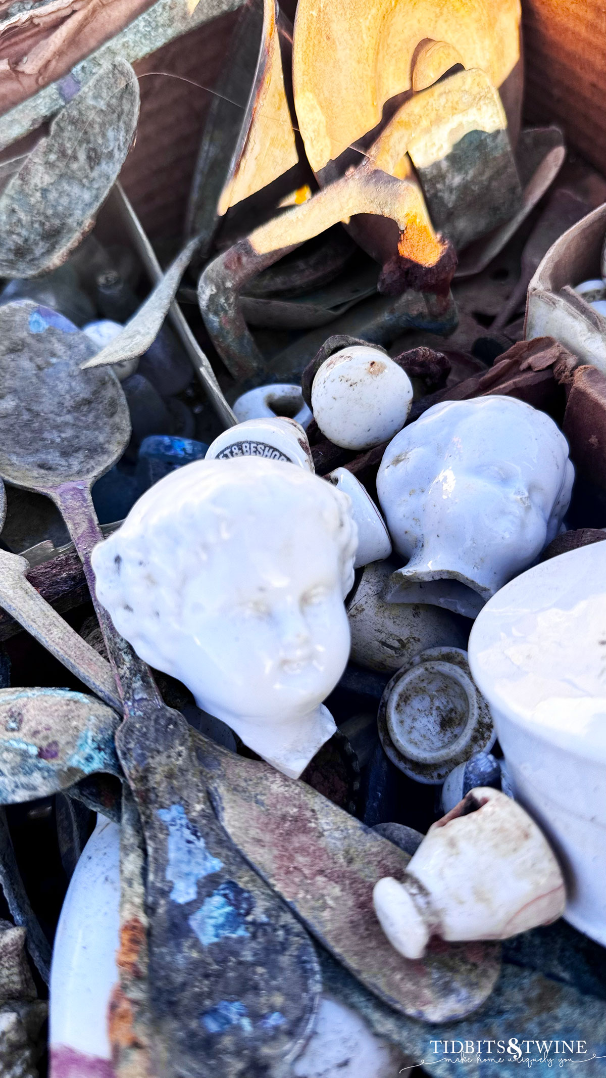 antique porcelain doll head in a basket with vintage spoons