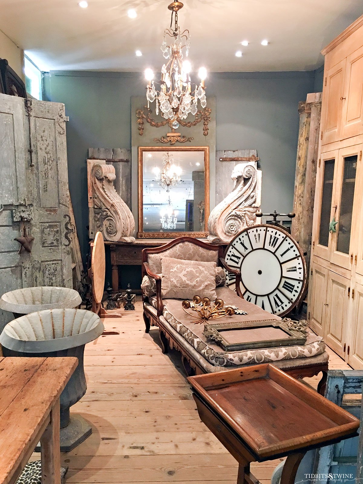 french antique store with crystal chandelier large clock and furniture