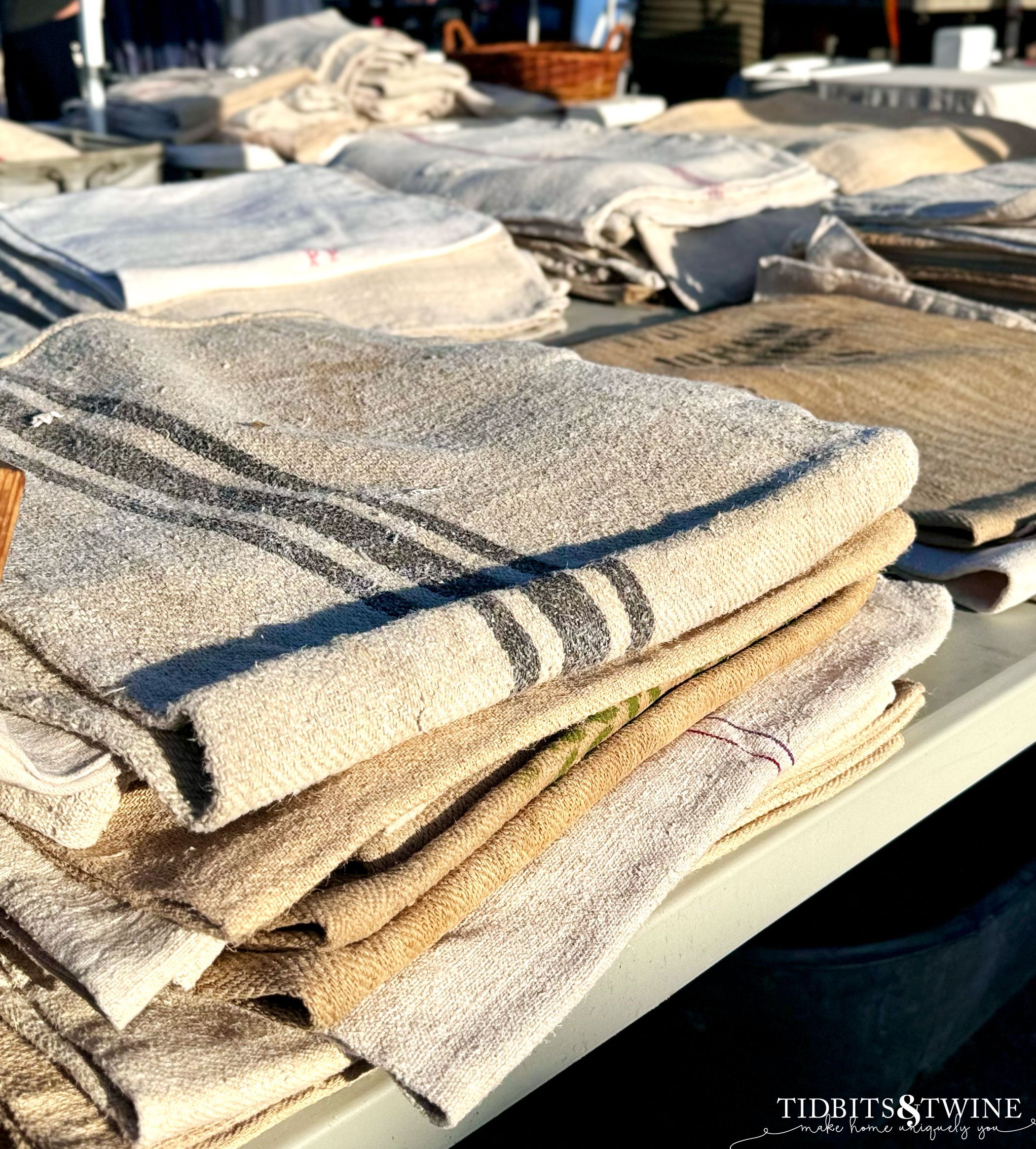 table stacked with folded vintage european grain sacks