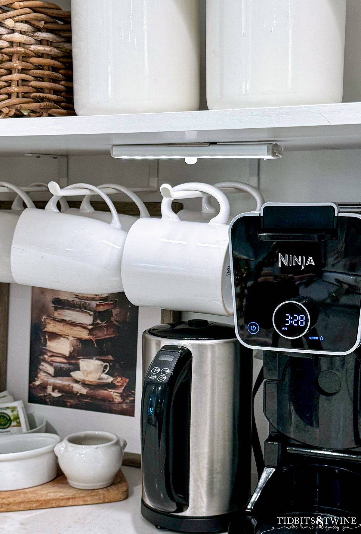 kitchen coffee cabinet with mugs on racks and coffee maker below with motion sensor light in cabinet