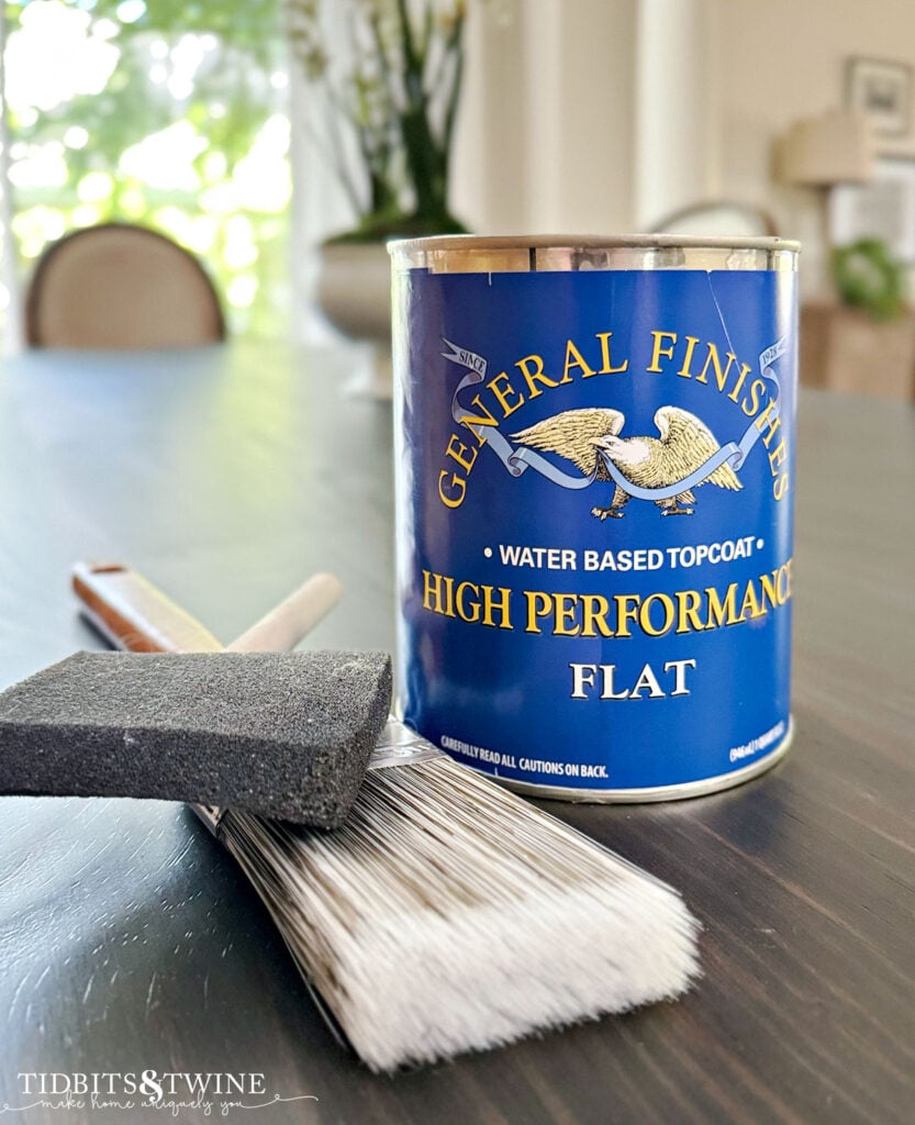 closeup of can of general finishes flat topcoat with two brushes next to the can