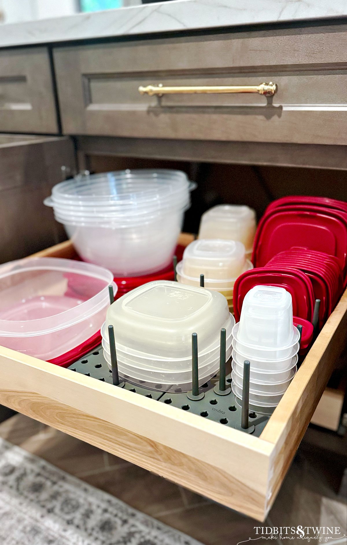 pullout drawer in kitchen with clear and red tupperware organized on peg holder