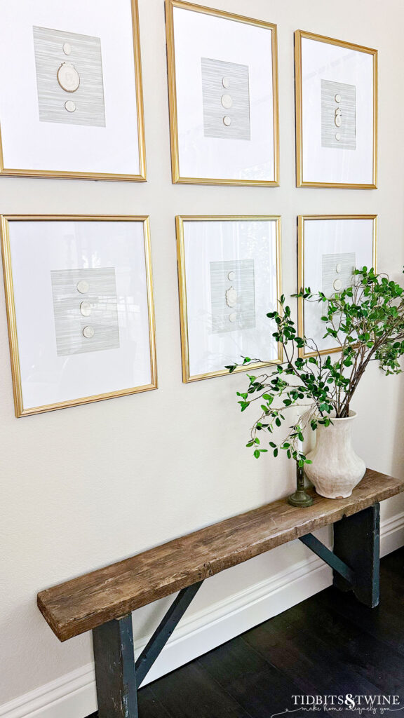 diy intaglios in gold frames hanging on a wall with a small bench beneath