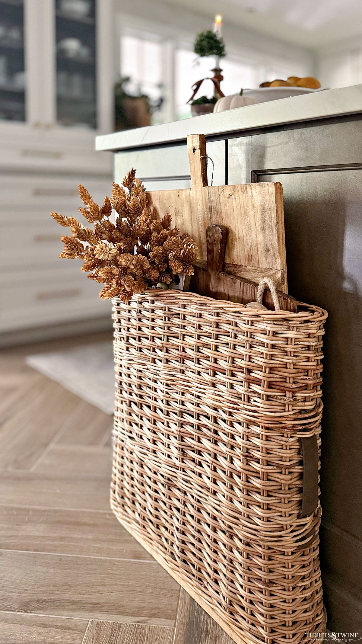 antique WWII artillery basket holding vintage bread boards in a warm white kitchen