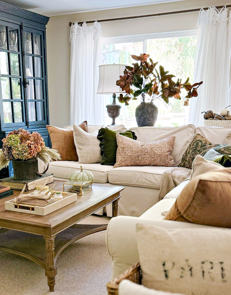 fall decorated family room with white slipcovered sofa and brown and green pillows - A Beautiful Fall Living Room!