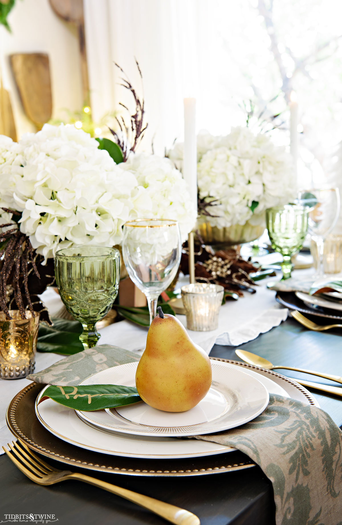 Christmas table setting with gold and white plates and white hydrangea - Christmas Dining Room Tour