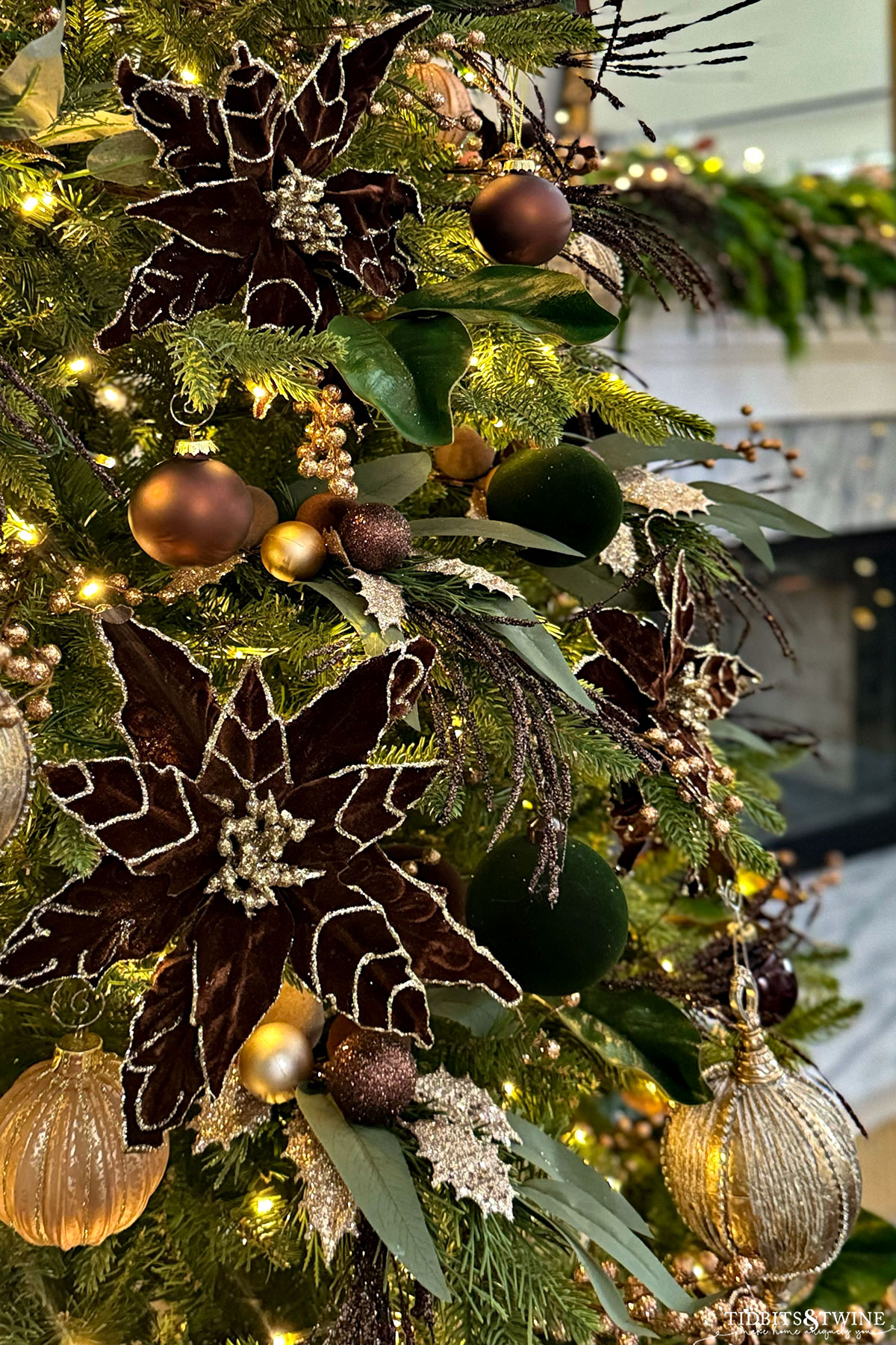 closeup of brown velvet poinsettia flowers on a christmas tree with gold ornaments
