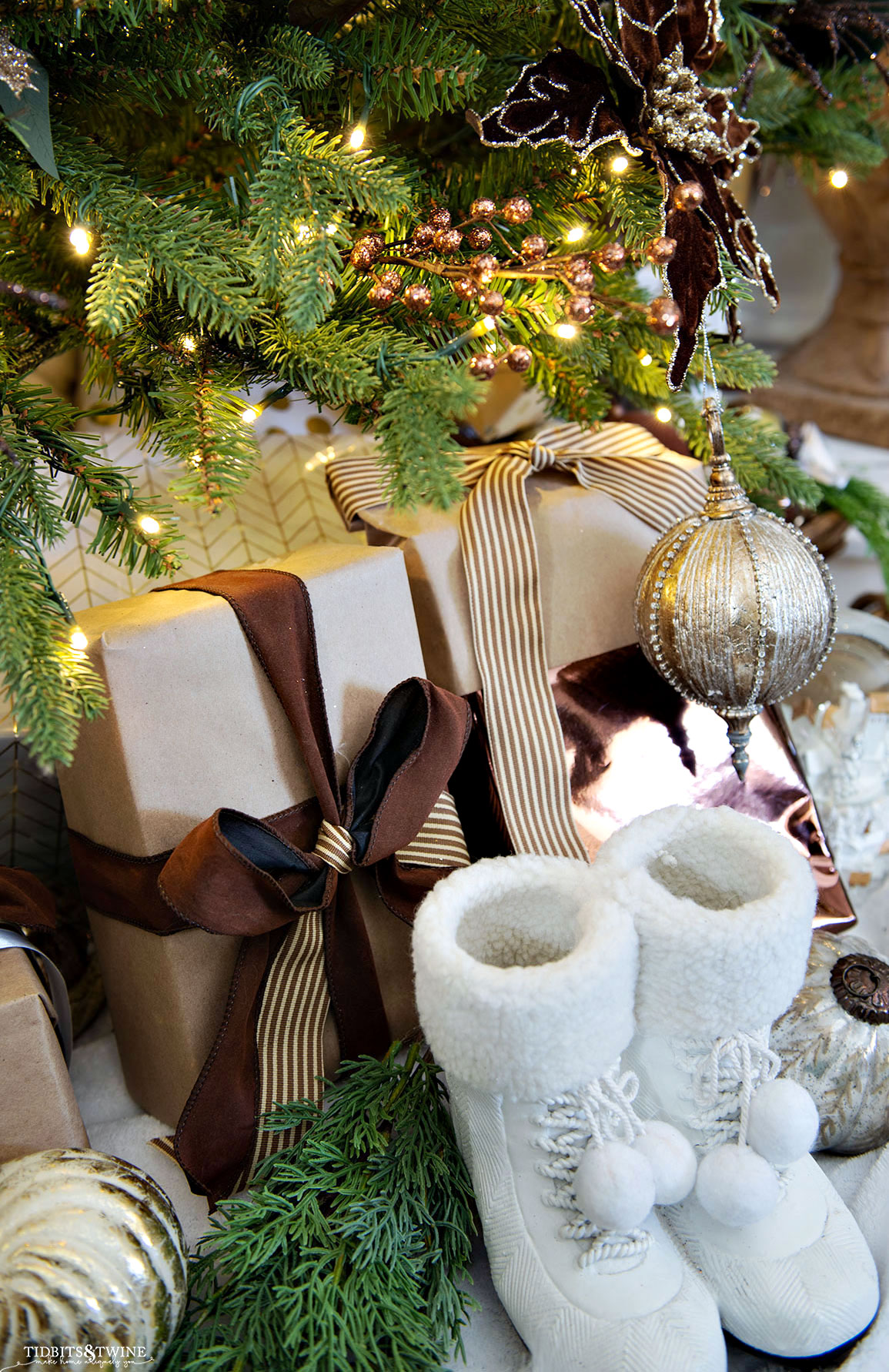 neutral wrapped christmas presents underneath the tree with other decor