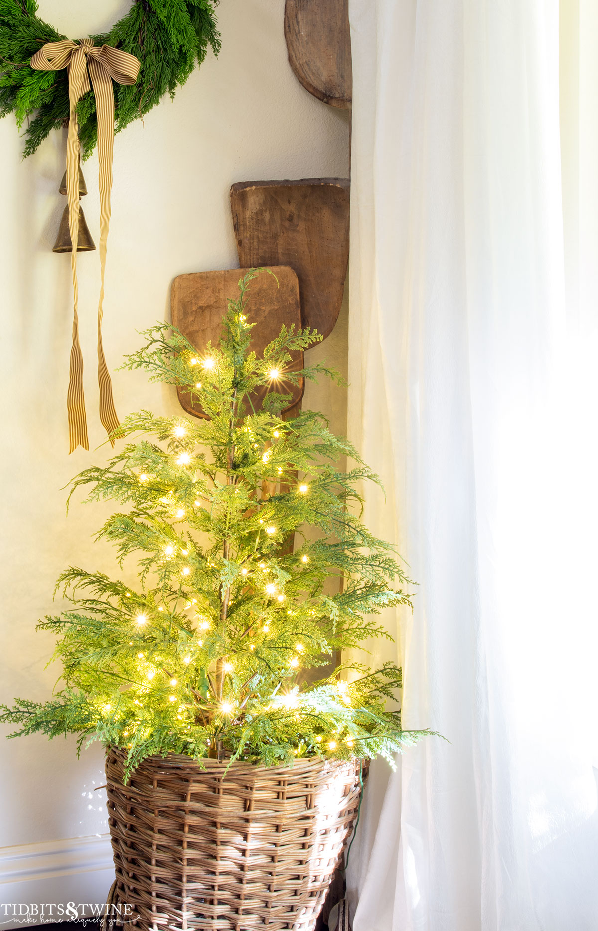 small christmas tree with fairy lights in a French market basket for Christmas corner