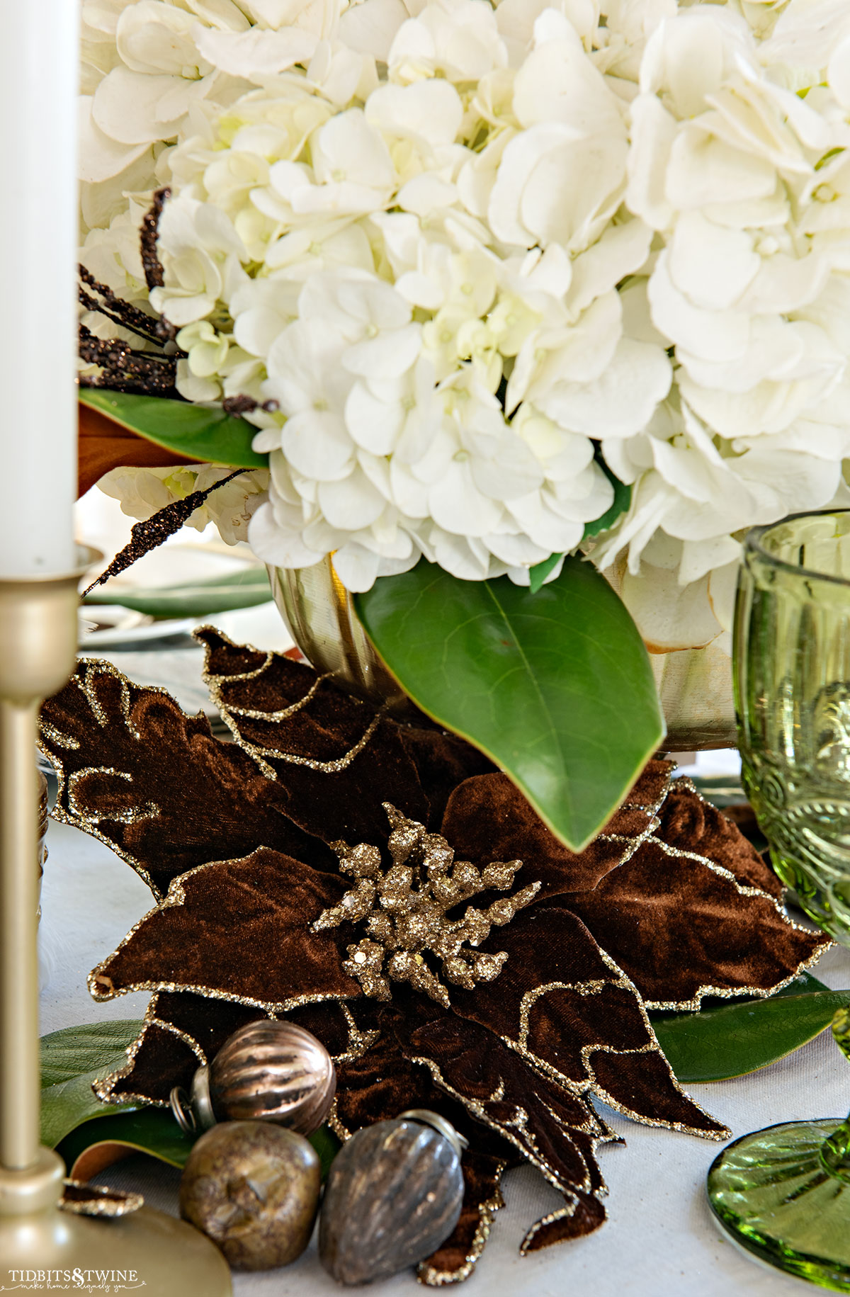 brown and gold velvet flower at the base of hydrangea arrangement on Christmas table