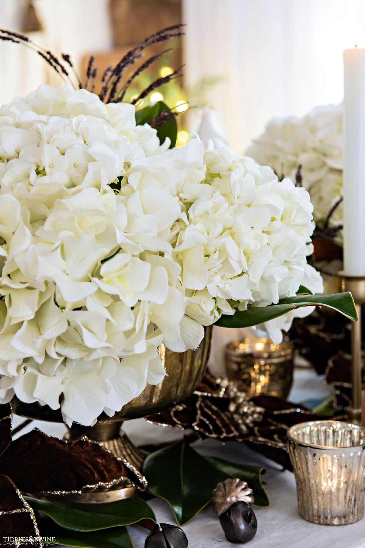 Mix of fake and real white hydrangeas in a gold compote for Christmas tablescape