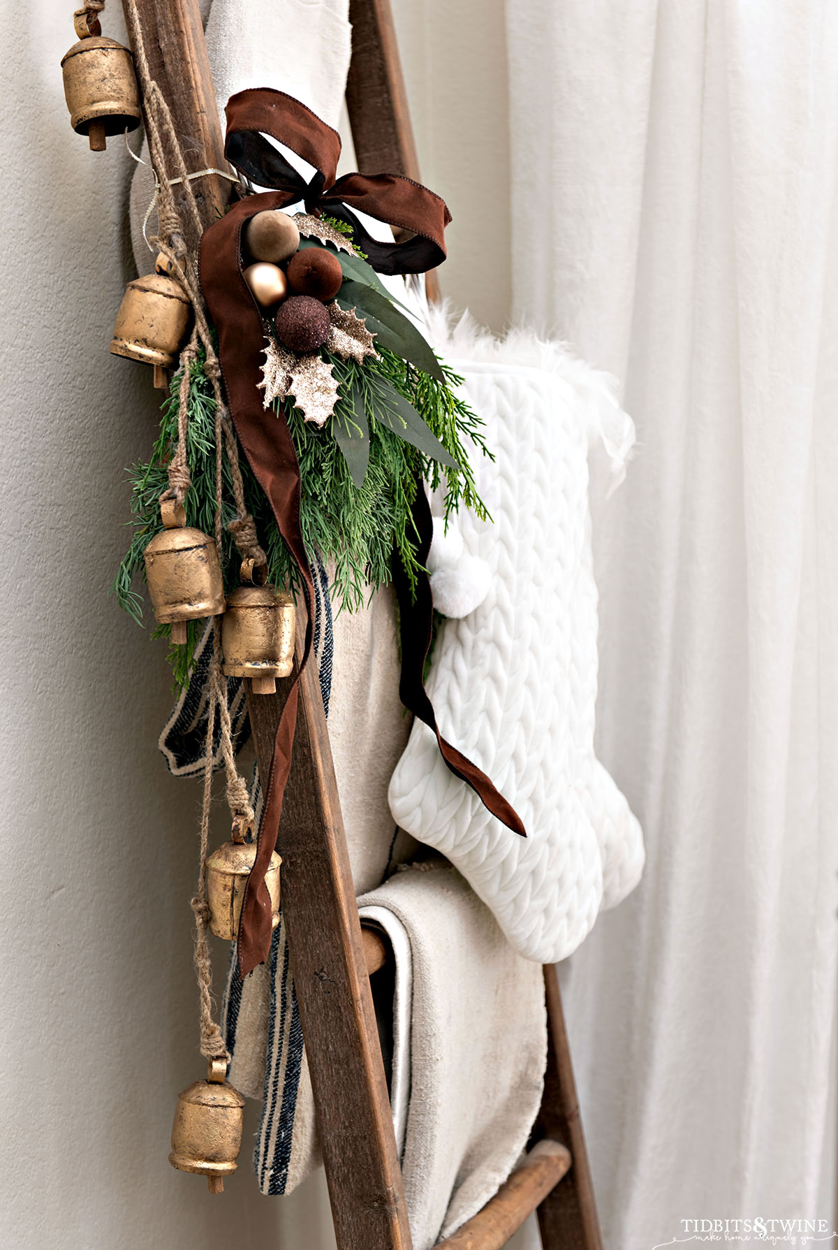 wooden blanket ladder decorated for christmas with stockings and bells