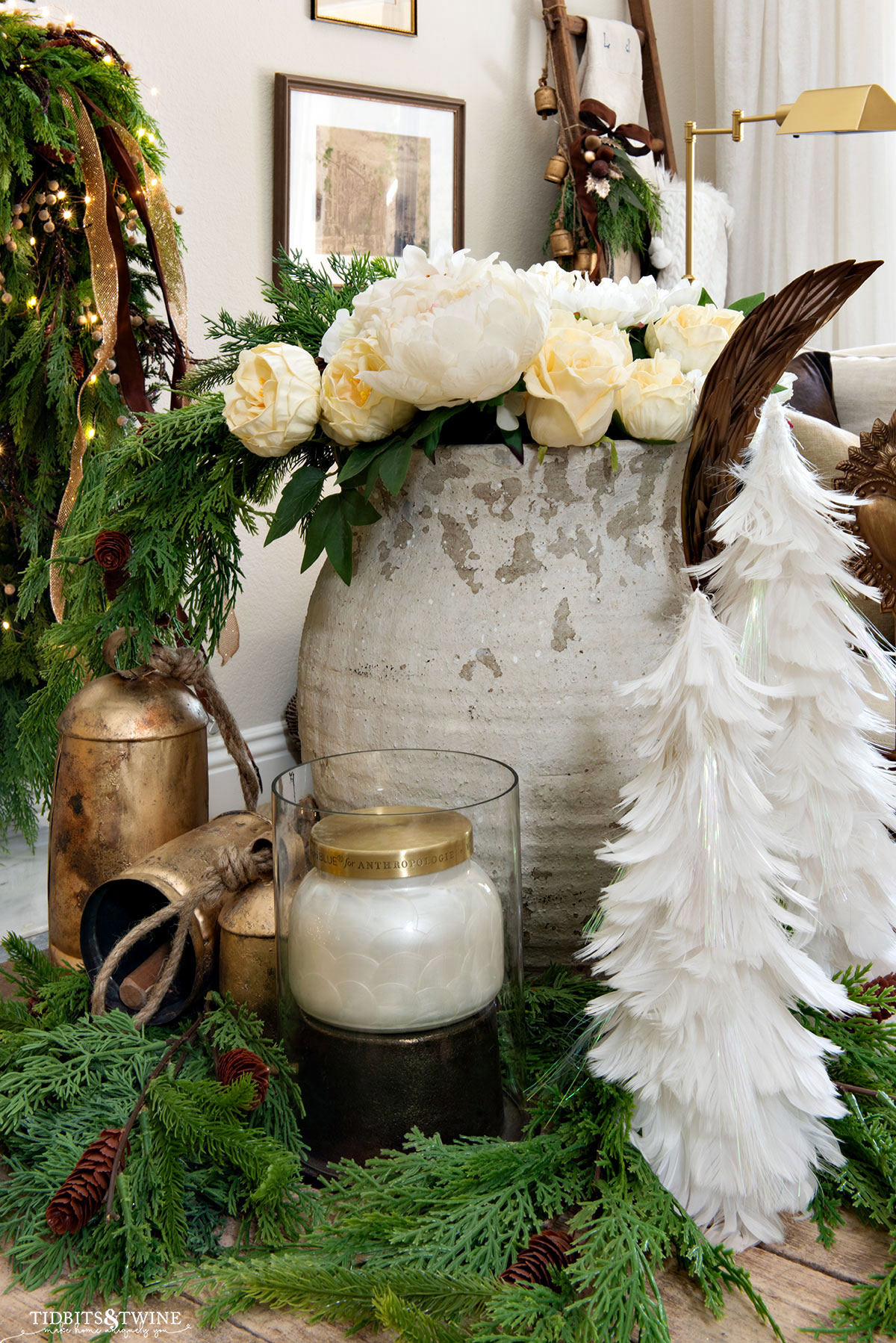French inspired Christmas vignette with white feather trees white flowers and brass bells