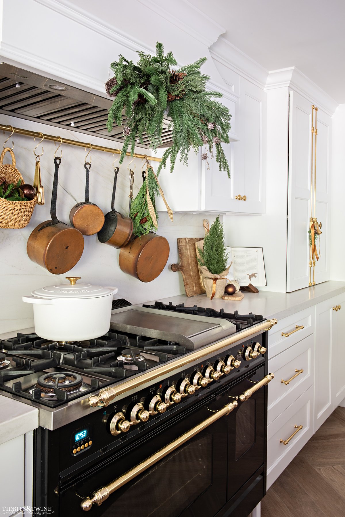 white kitchen cabinets with black italian range in kitchen decorated for christmas with greenery