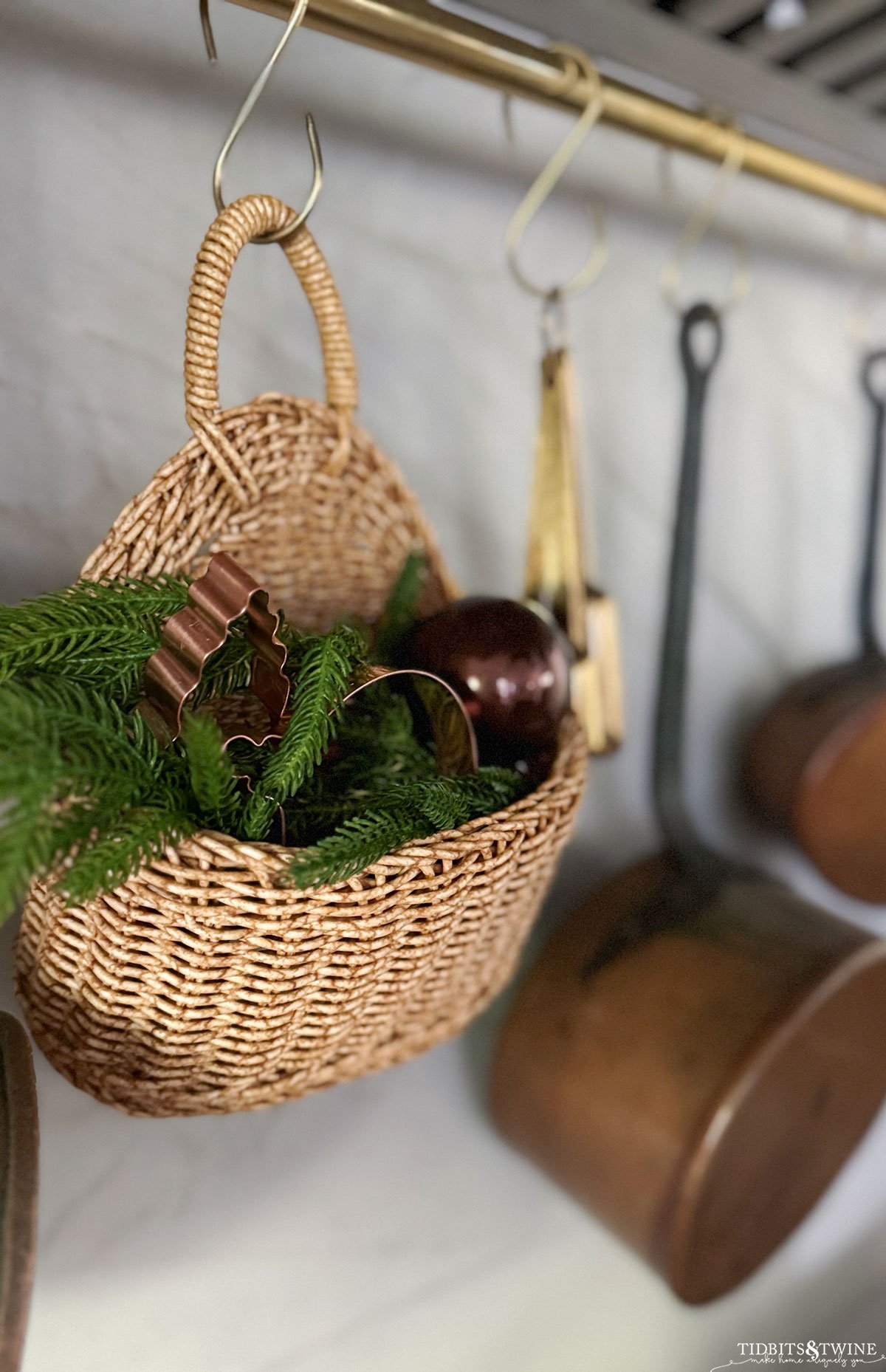 small basket with copper Christmas cookie cutters and greenery