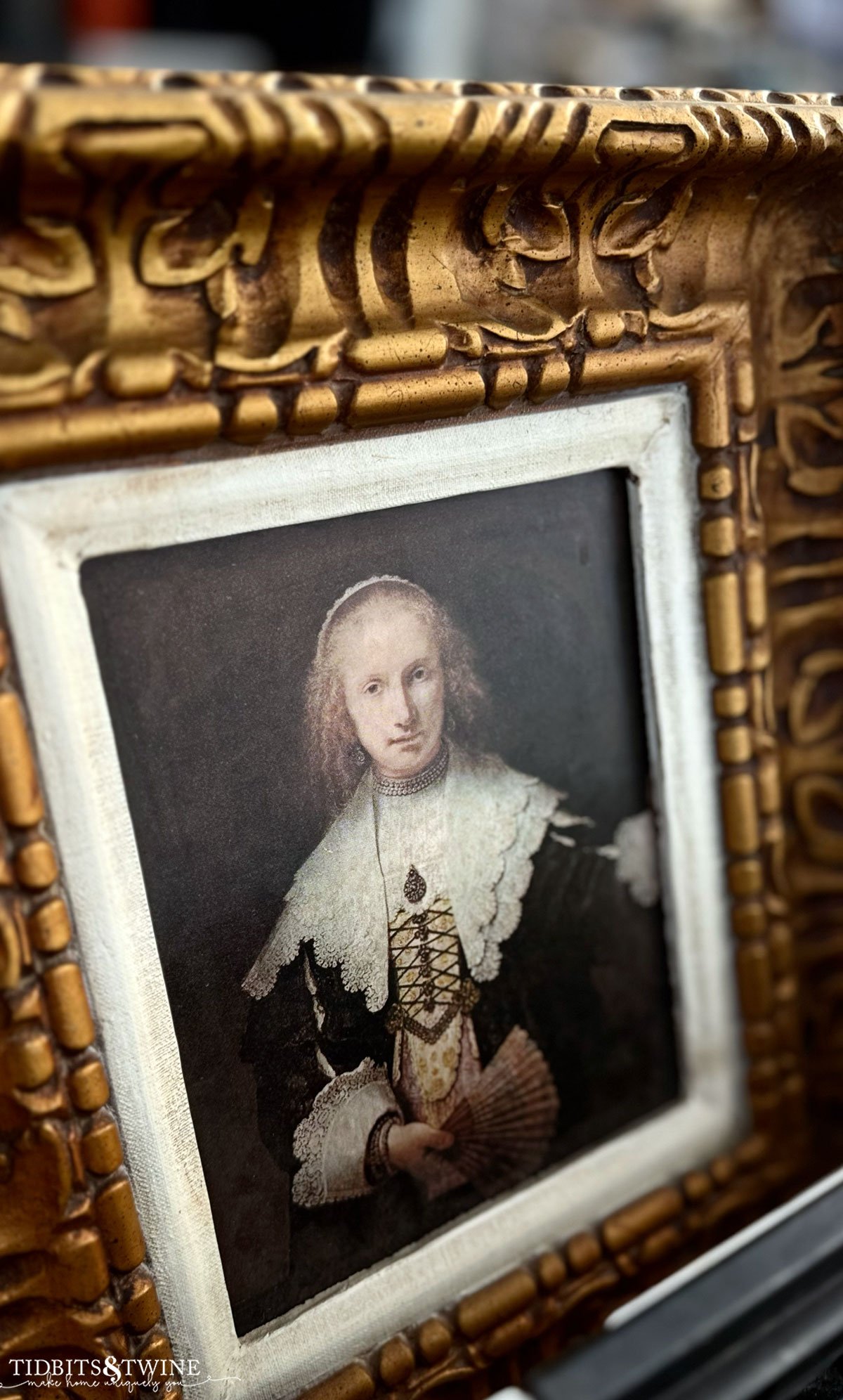 Framed antique portrait of a somber woman in dark clothing with a dramatic ruffled collar.