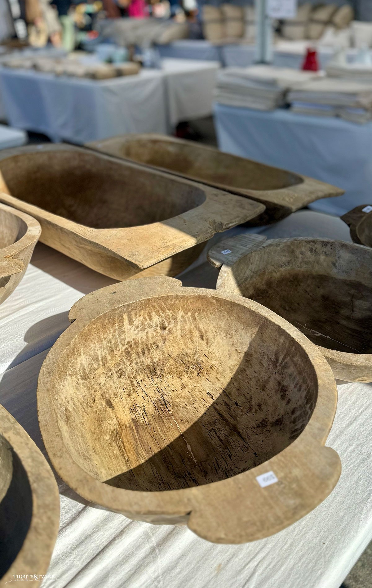 Collection of rustic wooden dough bowls of varying shapes and sizes displayed on a table.