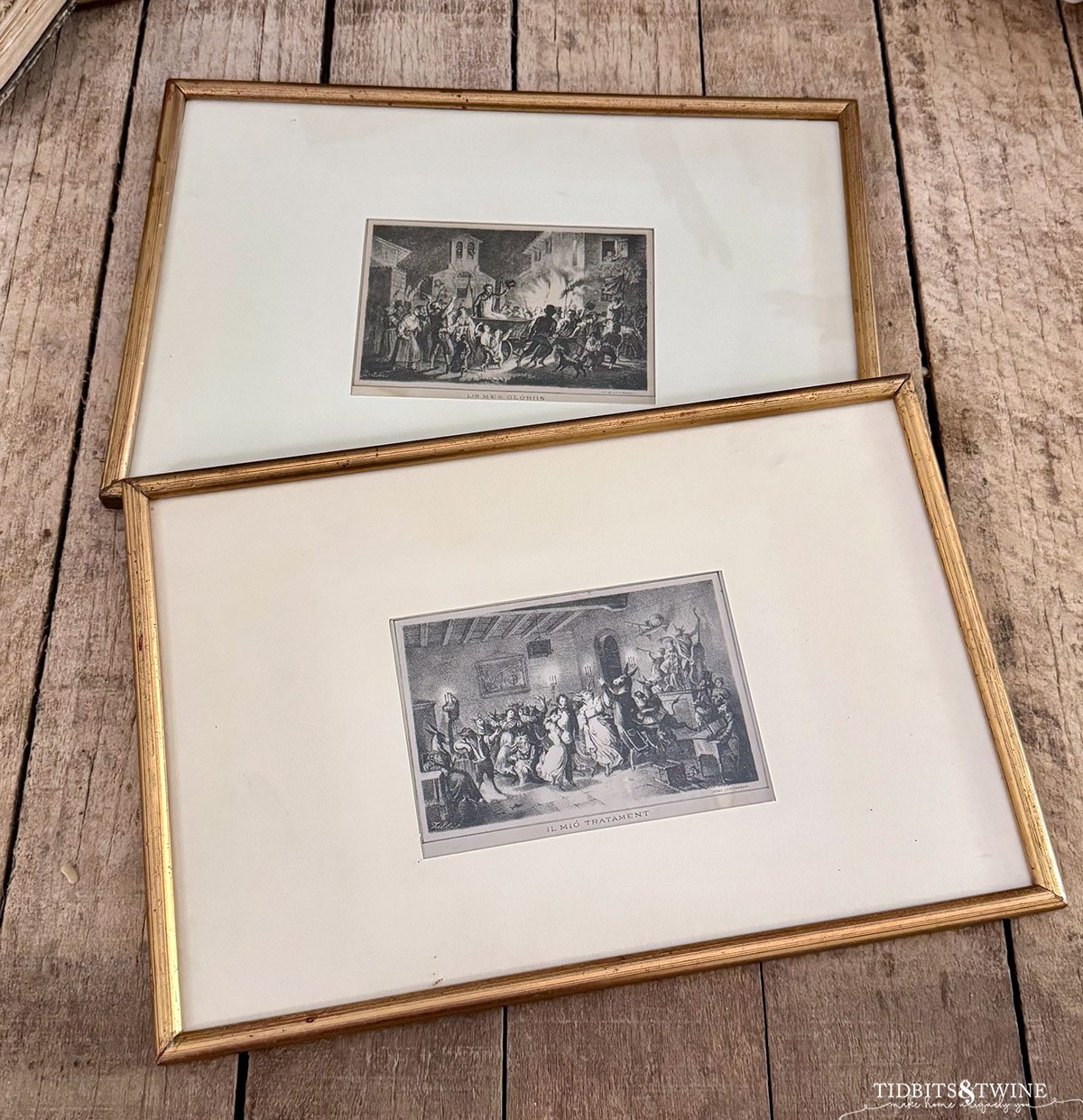 two gold framed pieces of Italian sketch art on a wooden table