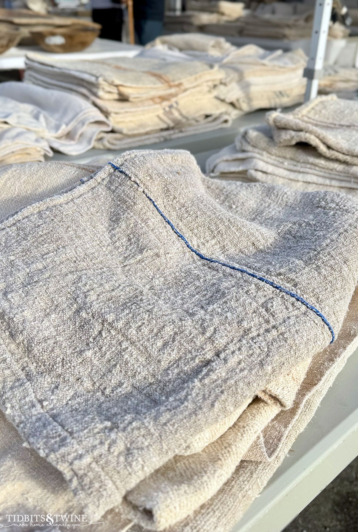 Stack of soft vintage grain sacks with faded blue and red stripe patterns.