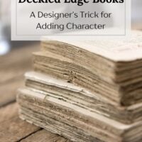 Stack of vintage deckled edge books with feathery, uneven pages styled on a rustic wood table — a designer’s trick for adding texture and character to home decor.